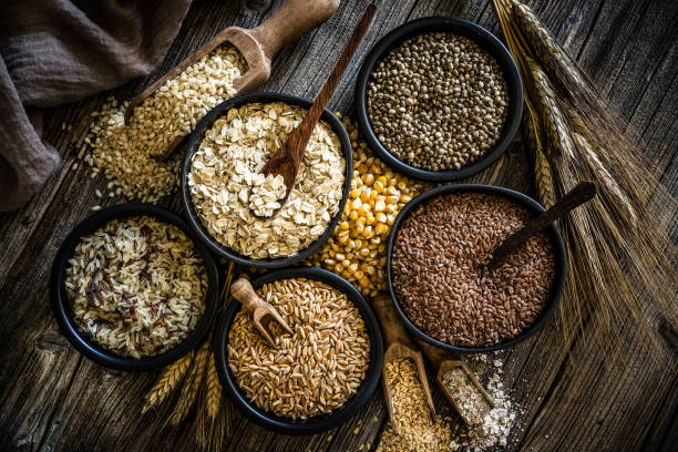 Top view of wholegrain and cereal composition shot on rustic wooden table. This type of food is rich of fiber and is ideal for dieting. The composition includes oat flakes, brown rice, dried corn,spelt, hemp seeds and flax seeds. Predominant color is brown. XXXL 42Mp studio photo taken with SONY A7rII and Zeiss Batis 40mm F2.0 CF